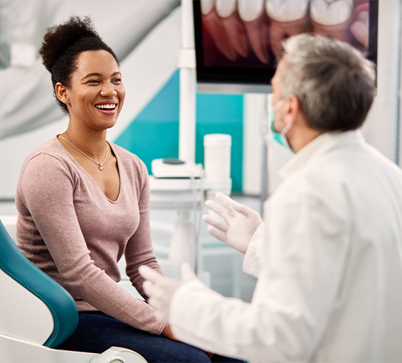 Woman smiling while listening to her dentist