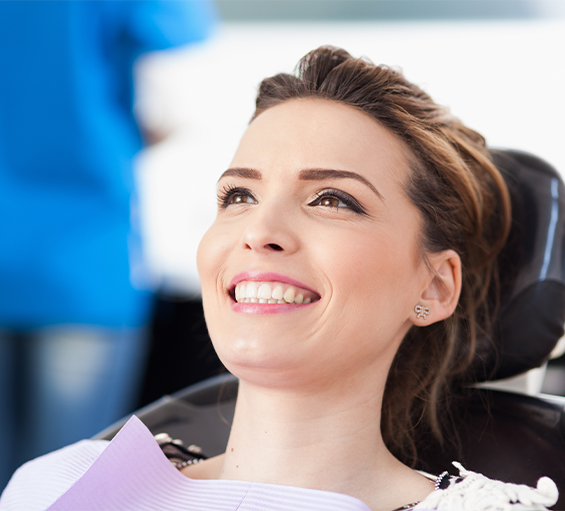 Smiling woman leaning back in dental chair