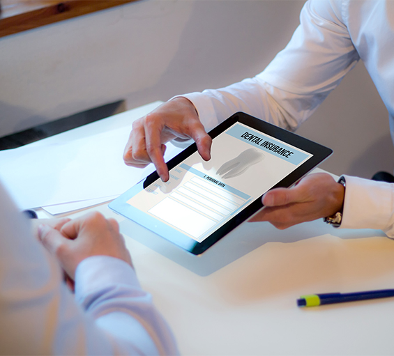 Two people looking at dental insurance form on tablet