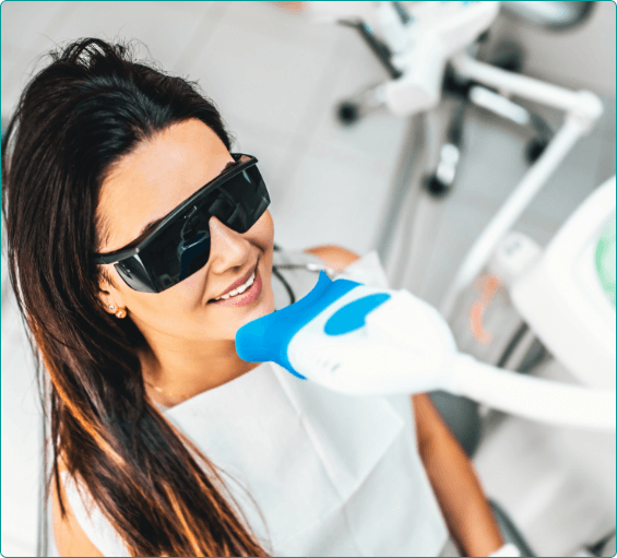 Woman getting professional teeth whitening in dental office