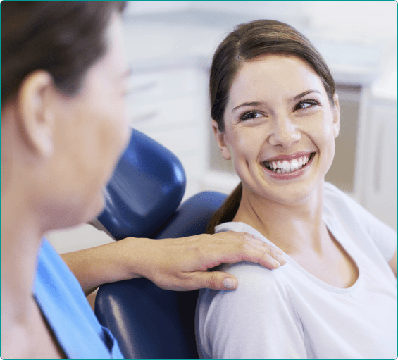 Woman in dental chair smiling at her dentist