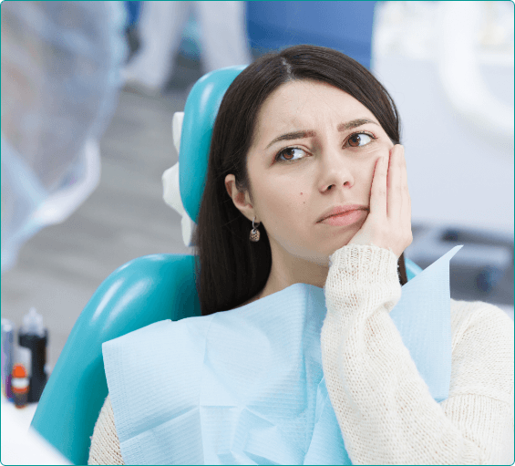 Emergency dental patient holding her cheek in pain