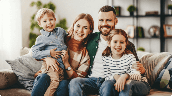 Smiling family of four sitting on couch