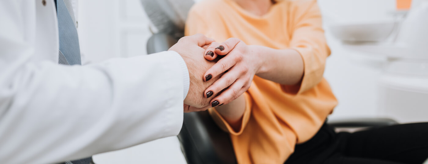 Close up of dental shaking hands with a dental patient