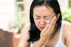 Woman in pain with her hand on her face