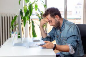 a worried man at his office calling an emergency dentist